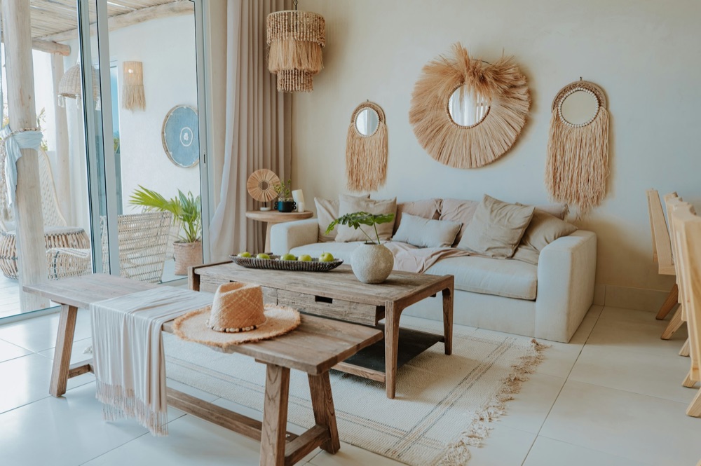 Living room with natural-fiber wall decor, woven pendants, and a low wooden coffee table